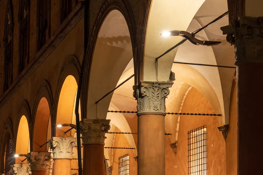 Dettaglio dei portici di piazza Santo Stefano a Bologna illuminati da Bird