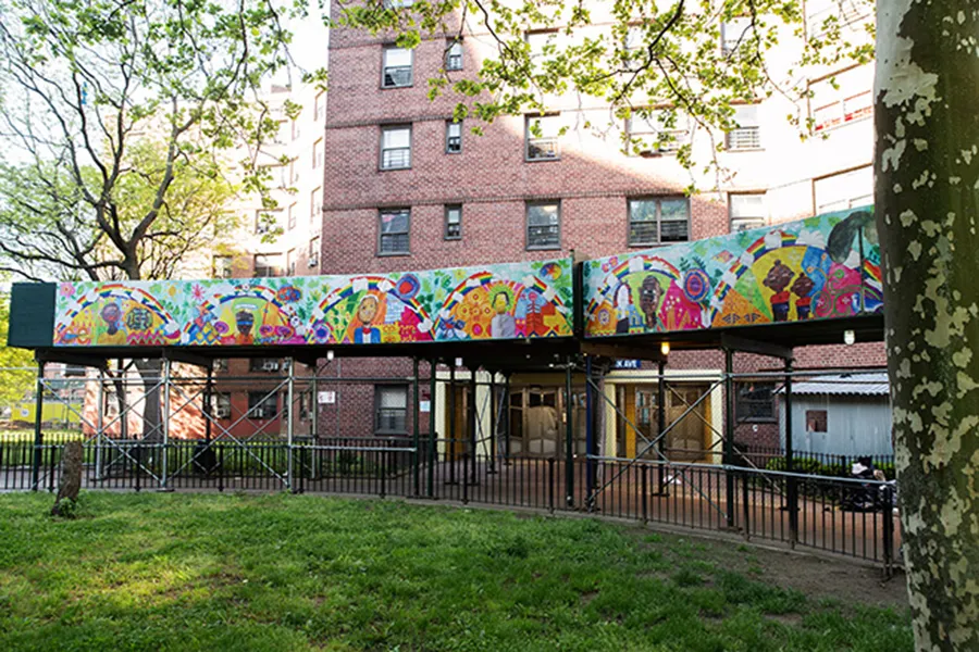 impalcature di cantiere a New York abbellite con opera di artista locale, che si ispira ai disegni realizzati dai bambini, alle persone che frequentano la biblioteca del quartiere e alla vegetazione del vicino giardino